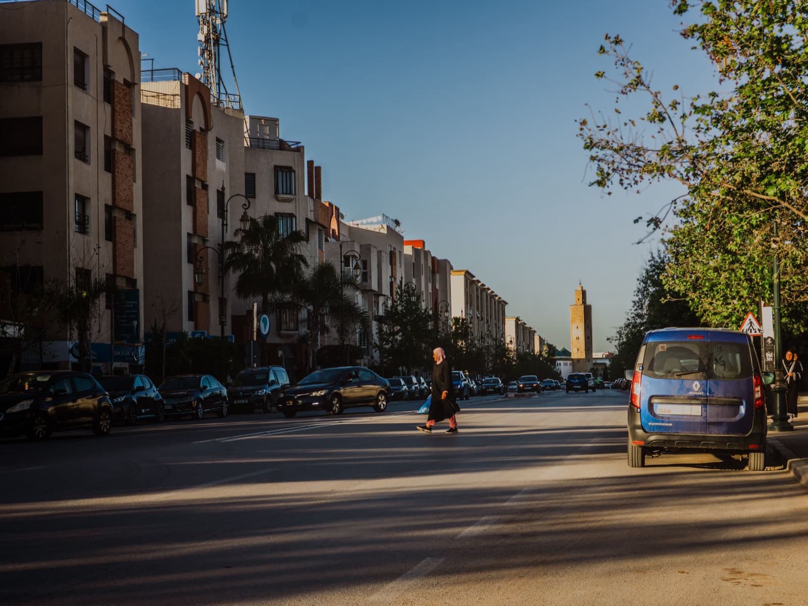 Grand boulevard marocain au lever du jour, minaret au loin